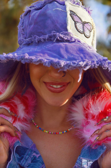 Purple Butterfly Tie Dye Denim Bucket Hat with Stash Pocket Smiling Portrait | Handmade Frayed Festival Hat | Neon Nomade & Alyssa Risley