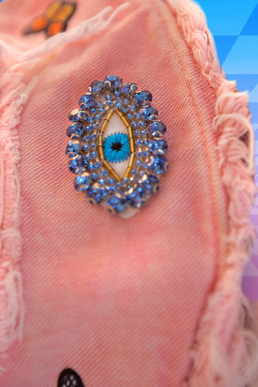 Close Up View of Brim of Pink Tie Die Bucket Hat with Evil Eyes Jewel Diamonds and Butterfly Patches and Frayed Edges | Festival Whimsigoth Fairy Patchwork Upcycled Rave Fashion | Neon Nomade