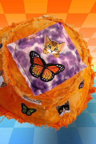 Fluorescent Neon Orange Cats Are Fly Tie Dye Denim Bucket Hat Top View with Tiger Kitty Cat and Butterfly Patches on Putple Batik Patch with Frayed Distressed Edges | One of a Kind Festival Rave Burning Man Fashion for Coachella EDC LIB Electric Forest Forestcore Whimsigoth Shambhala | Neon Nomade