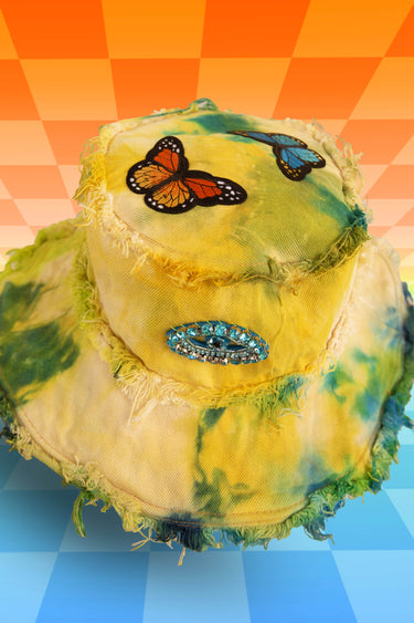 Top View of Handmade Yellow Blue Green Third Eye Tie Dye Denim Bucket Hat with Butterflies and Jewel Diamond Evil Eyes and Frayed Distressed Edges | One of a Kind Festival Rave Burning Man Coachella EDC LIB Electric Forest Fashion | Neon Nomade